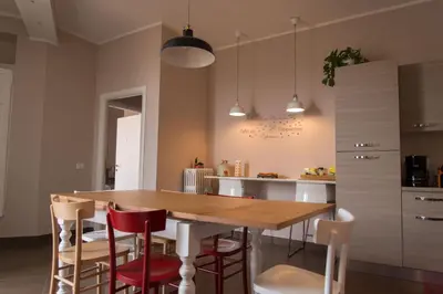 a kitchen with a wooden table and red chairs at La Terrazza di Evelina Guest House in Rome