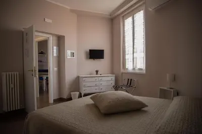 a bedroom with a bed and a dresser and a window at La Terrazza di Evelina Guest House in Rome