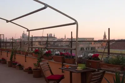 a balcony with a table and potted plants at La Terrazza di Evelina Guest House in Rome