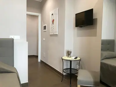 a living room with a small table and a tv on the wall at La Terrazza di Evelina Guest House in Rome