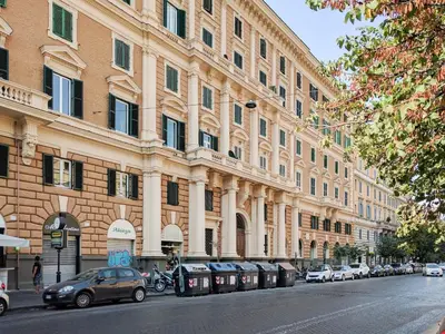 a large building with cars parked on the side of a street at Le Stanze Di Federica in Rome
