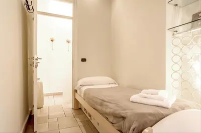 a white room with two beds and a shower at GuestHost - Palazzo Farnese Historical Home in Rome