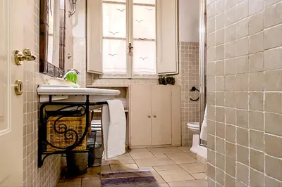 a bathroom with a sink and a toilet and a mirror at GuestHost - Palazzo Farnese Historical Home in Rome