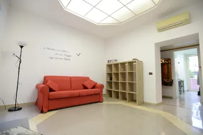 a red couch in a room with a wall at Casa Andrew in Rome