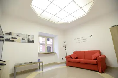 a living room with a red chair and a table at Casa Andrew in Rome