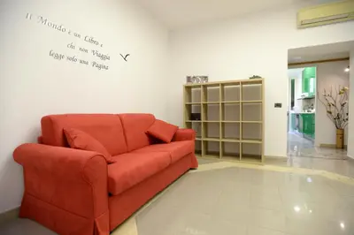 a red couch in a room with a wall with writing at Casa Andrew in Rome