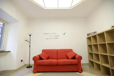 a red couch sitting in a room with shelves at Casa Andrew in Rome