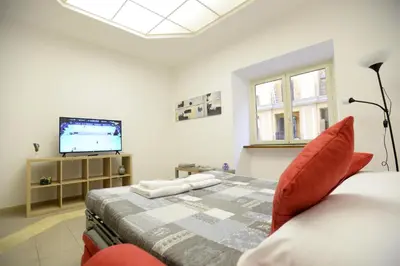 a bedroom with a bed and a flat screen tv at Casa Andrew in Rome