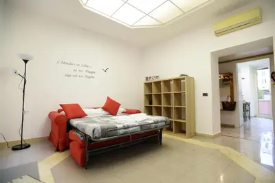 a room with a bed with a red chair in it at Casa Andrew in Rome