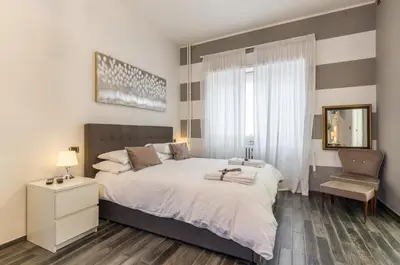 a bedroom with a large bed and a chair at Trastevere Sweet House in Rome
