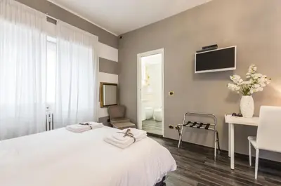 a bedroom with a bed and a table and a tv at Trastevere Sweet House in Rome