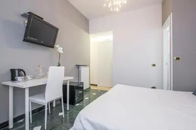 a bedroom with a bed and a table and a tv at Trastevere Sweet House in Rome