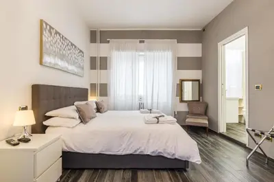 a bedroom with a large bed and a chair at Trastevere Sweet House in Rome