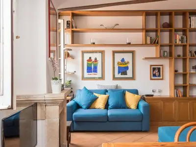 a living room with a blue couch and shelves at TREVI luxury with terrace in Rome