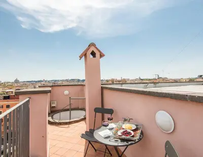 a balcony with a table with a plate of food on it at TREVI luxury with terrace in Rome