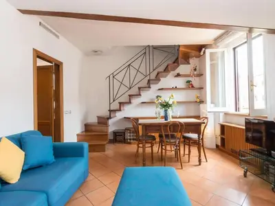 a living room with a blue couch and a table at TREVI luxury with terrace in Rome
