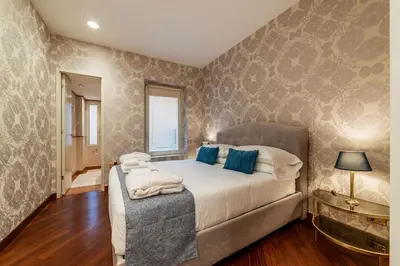 a bedroom with a large bed with blue pillows at Piazza di Spagna 90 Exclusive Apartment in Rome