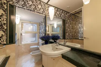 a bathroom with a sink and a toilet and a mirror at Piazza di Spagna 90 Exclusive Apartment in Rome