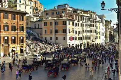 a crowd of people walking down a street with horse drawn carriages at Piazza di Spagna 90 Exclusive Apartment in Rome