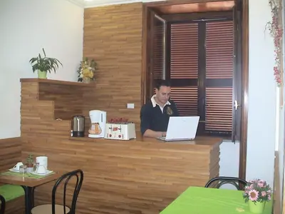 a man sitting at a counter with a laptop at B&B La Casa Di Rosy in Rome
