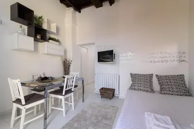 a living room with a table and chairs and a couch at White Terrace Ostilia in Rome