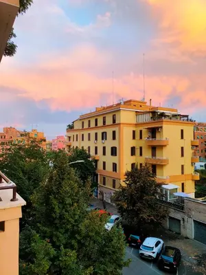 a yellow building with cars parked in a parking lot at Sweet home Appio Latino in Rome