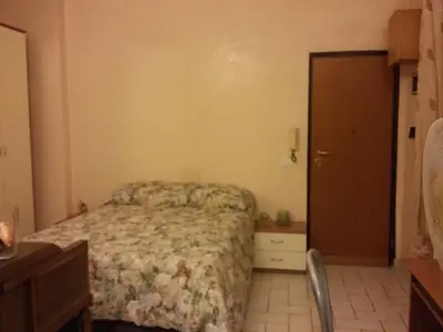 a bedroom with a bed and a dresser and a door at Monolocale Monteverde in Rome