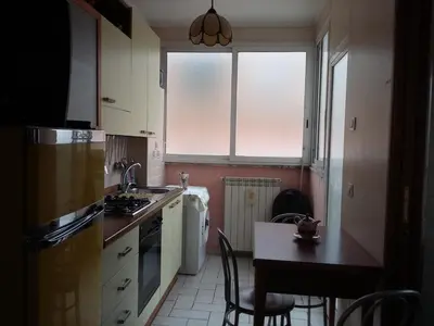 a kitchen with white cabinets and a table with chairs at Monolocale Monteverde in Rome