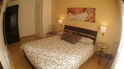 a bedroom with a bed with two chairs and a painting at Casa Giramondo in Rome