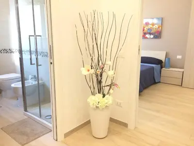 a white vase with flowers in a bathroom at Stephen Accommodation in Rome