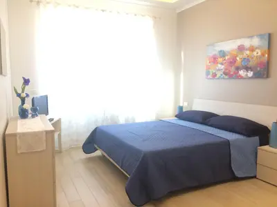 a bedroom with a blue bed and a large window at Stephen Accommodation in Rome