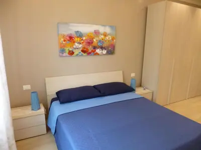 a bedroom with a blue bed and a painting on the wall at Stephen Accommodation in Rome