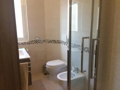 a bathroom with a toilet and a shower and a sink at Stephen Accommodation in Rome