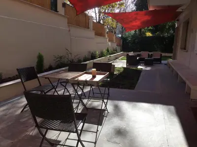 a patio with a wooden table and chairs and a table and chairs at Cadlolo Luxury Retreat - Rome Cavalieri and Villa Miani in Rome