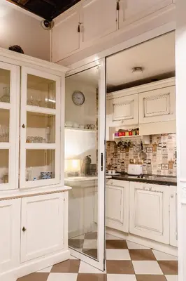 a kitchen with white cabinets and a glass door at Locanda Del Sole-Roma Piazza Di Spagna Ripetta in Rome