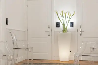 a white vase with flowers in it next to two chairs at Residenza Zanardelli in Rome
