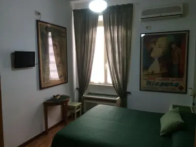 a bedroom with a green bed and a window at Vacanze Romane 2 in Rome