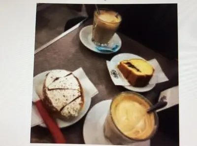 a table with plates of desserts and two cups of coffee at Vacanze Romane 2 in Rome