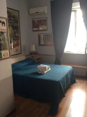 a bedroom with a blue bed with towels on it at Vacanze Romane 2 in Rome