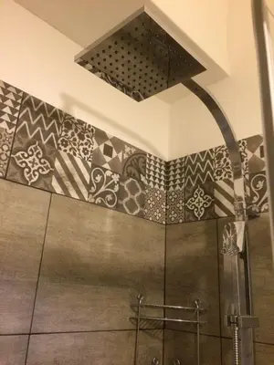 a bathroom with a shower with tiles on the wall at Vacanze Romane 2 in Rome