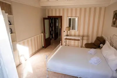 a bedroom with a white bed and a chair at Mario's apartament in the Spanish Steps in Rome