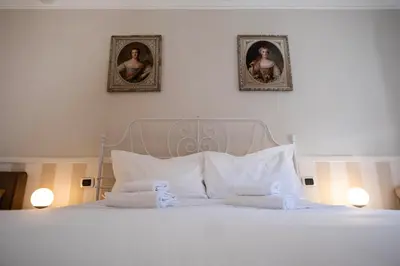 a bedroom with a white bed with two pictures on the wall at Mario's apartament in the Spanish Steps in Rome
