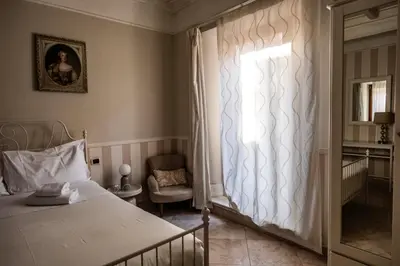 a bedroom with a bed and a window and a chair at Mario's apartament in the Spanish Steps in Rome