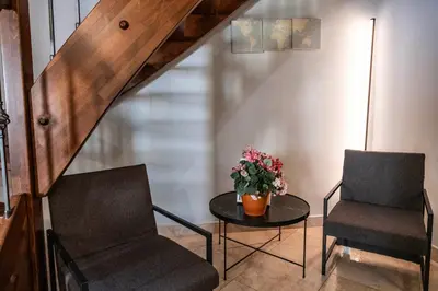 two chairs and a table with a vase of flowers at Mario's apartament in the Spanish Steps in Rome