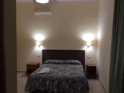 a bedroom with a bed and two lights on the wall at Albergo Enrica in Rome