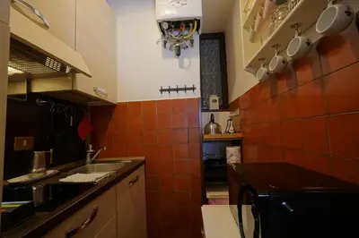 a small kitchen with orange tiles on the wall at MGPgroup Rome Center Hot Spot in Rome