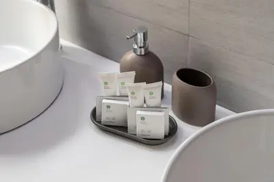 a bathroom counter with a bottle of soap and a cup at Trevi Luxury Terrace in Rome