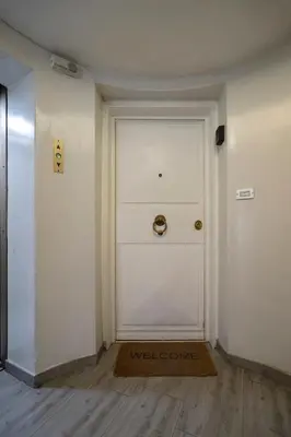 a hallway with a white door and a welcome mat at Trevi Luxury Terrace in Rome