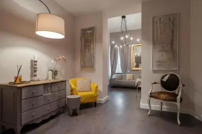 a living room with a dresser and a yellow chair at Trevi Luxury Terrace in Rome