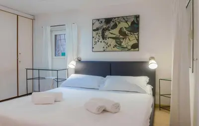 a bedroom with a white bed with two towels on it at My Cosy Home in Rome